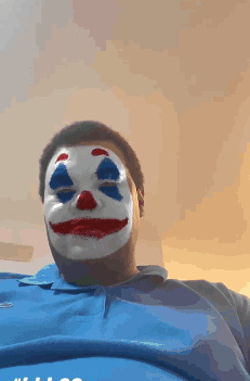 A Man Wearing A Clown Mask And A Blue Shirt GIF