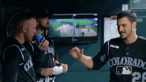 A Man Wearing A Colorado Jersey Is Talking To Another Man GIF