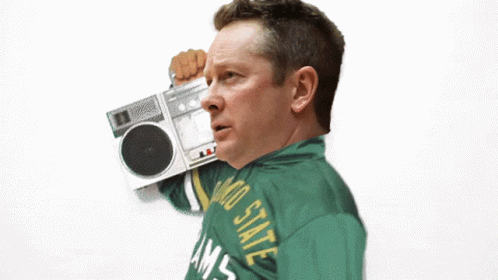 a man wearing a colorado state rams jacket holds a boombox