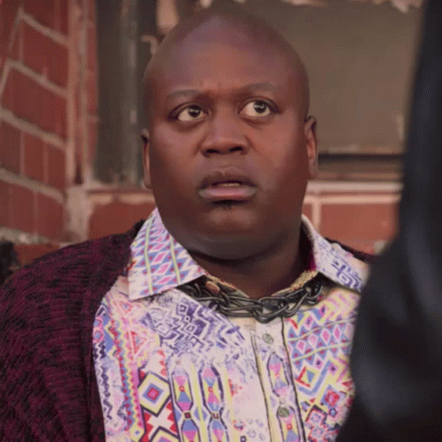 A Man Wearing A Colorful Shirt And A Chain Around His Neck GIF