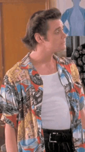 A Man Wearing A Colorful Shirt And A White Tank Top . GIF