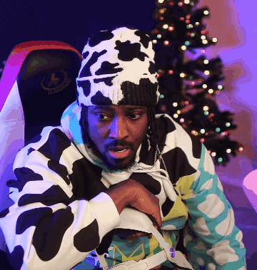 A Man Wearing A Cow Print Hat Is Sitting In Front Of A Halo Chair GIF