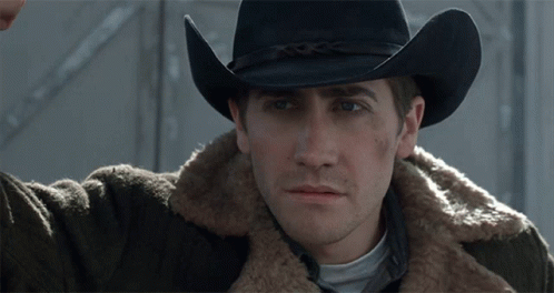 A Man Wearing A Cowboy Hat And A Brown Jacket GIF