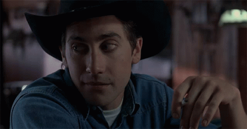 A Man Wearing A Cowboy Hat And A Denim Shirt GIF