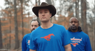 a man wearing a cowboy hat and a wildwood lective shirt