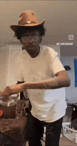 A Man Wearing A Cowboy Hat And Glasses Is Dancing In A Living Room GIF