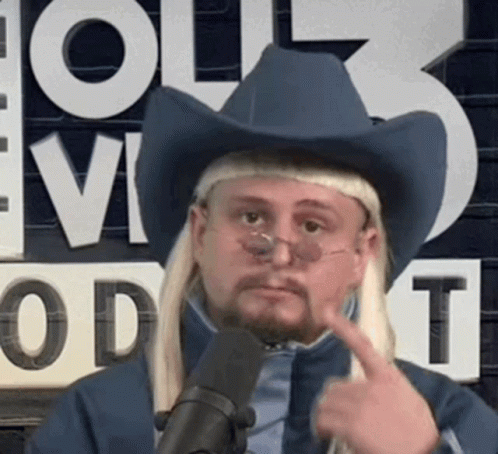 A Man Wearing A Cowboy Hat And Glasses Is Pointing To His Face . GIF