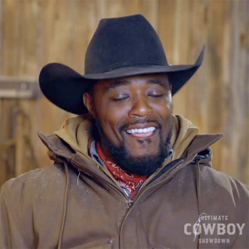 A Man Wearing A Cowboy Hat And Jacket Is Smiling GIF