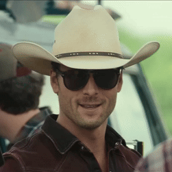 A Man Wearing A Cowboy Hat And Sunglasses Looks At The Camera GIF