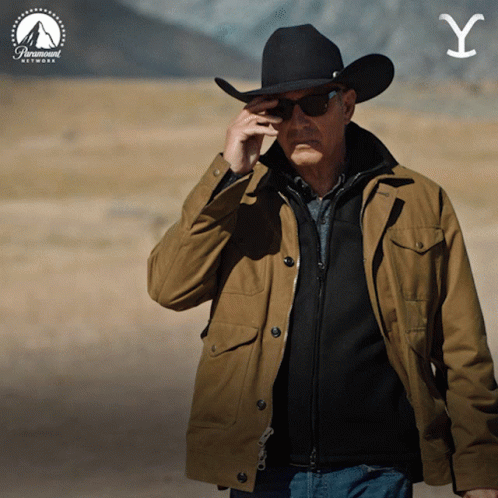 A Man Wearing A Cowboy Hat And Sunglasses Talks On A Cell Phone GIF