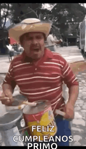 A Man Wearing A Cowboy Hat Is Playing A Drum And Singing . GIF
