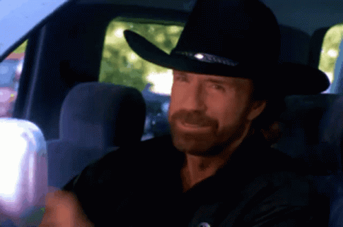 A Man Wearing A Cowboy Hat Is Sitting In A Car GIF