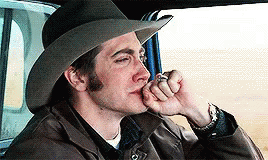 A Man Wearing A Cowboy Hat Is Smoking A Cigarette In A Car GIF