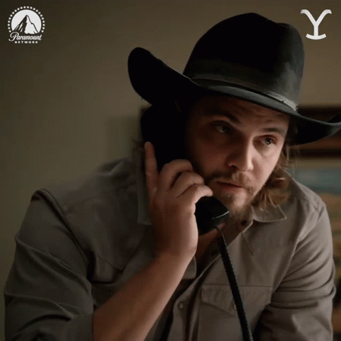 A Man Wearing A Cowboy Hat Is Talking On A Phone And The Word Yup Is On The Bottom GIF