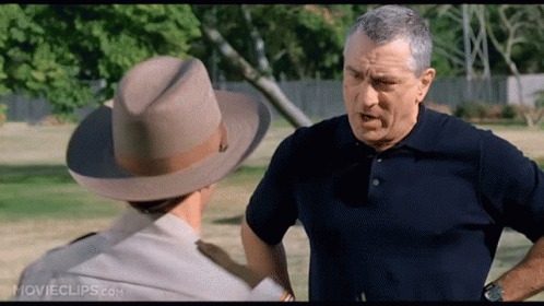 A Man Wearing A Cowboy Hat Is Talking To Another Man GIF
