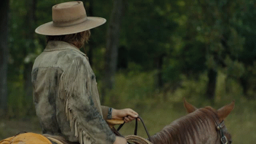 A Man Wearing A Cowboy Hat Rides A Horse GIF