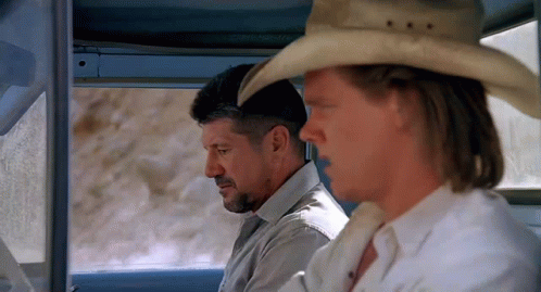 A Man Wearing A Cowboy Hat Sits Next To Another Man GIF