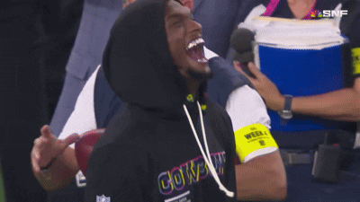 A Man Wearing A Cowboys Hoodie Laughs While Watching A Football Game GIF