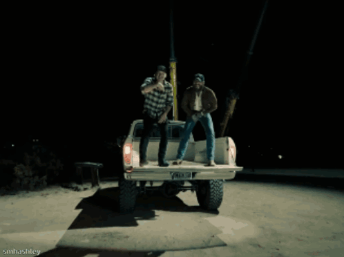 A Man Wearing A Dallas Hat Is Laughing While Sitting Next To Another Man GIF