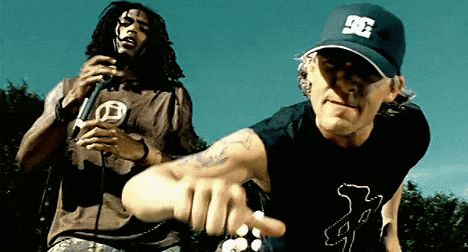 A Man Wearing A Dc Hat Is Pointing At Another Man GIF