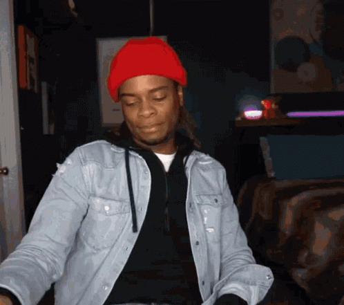 A Man Wearing A Denim Jacket And A Red Beanie GIF