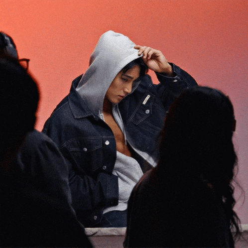 A Man Wearing A Denim Jacket With A Hood On His Head GIF