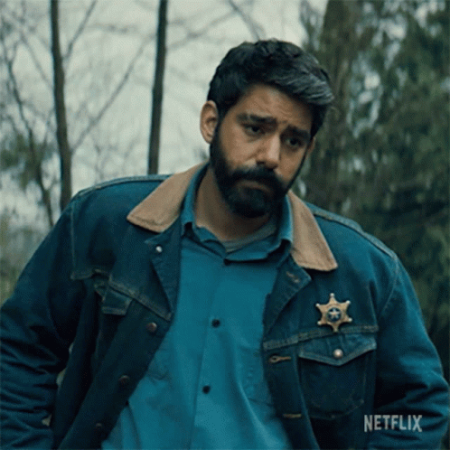 A Man Wearing A Denim Jacket With A Sheriff 'S Badge On His Chest GIF