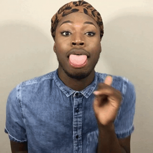 A Man Wearing A Denim Shirt And A Leopard Print Headband Is Sticking His Tongue Out GIF