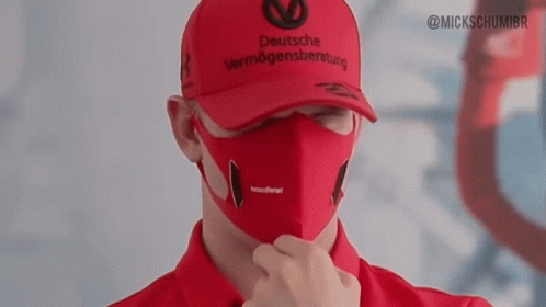 a man wearing a deutsche vermögensberatung hat and a face mask