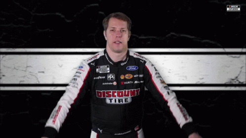 A Man Wearing A Discount Tire Shirt Holds A Checkered Flag GIF