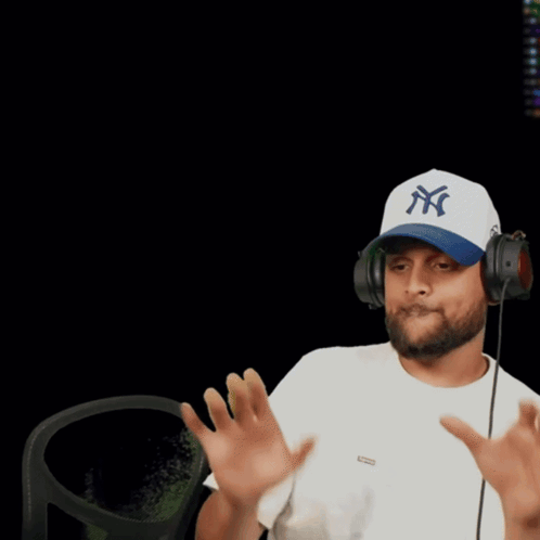a man wearing a dodgers hat holds his hands up