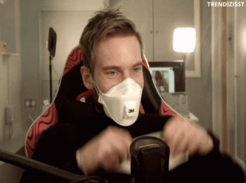 A Man Wearing A Face Mask Is Sitting In A Chair With The Words Trendizisst Above Him GIF