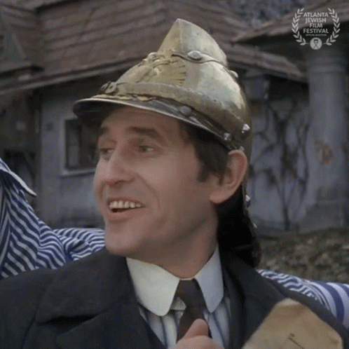 A Man Wearing A Fireman 'S Helmet Is Smiling In Front Of An Atlanta International Film Festival Sign GIF