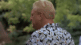 A Man Wearing A Floral Shirt Is Standing In Front Of A Tree . GIF