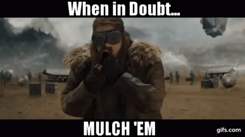 A Man Wearing A Fur Coat And Goggles Is Holding A Gun With The Words When In Doubt Mulch 'Em Below Him GIF
