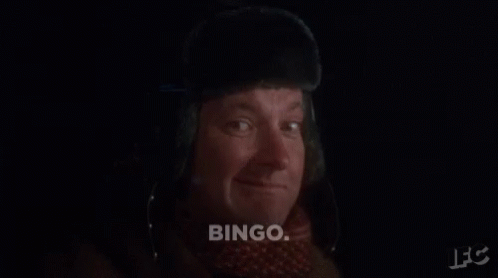 A Man Wearing A Fur Hat And Scarf Says " Bingo " GIF