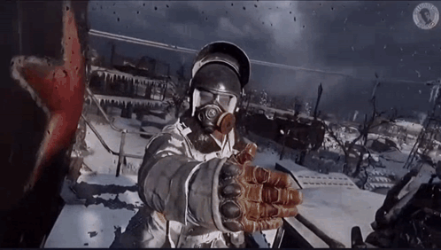 A Man Wearing A Gas Mask And Gloves Stands In The Snow GIF