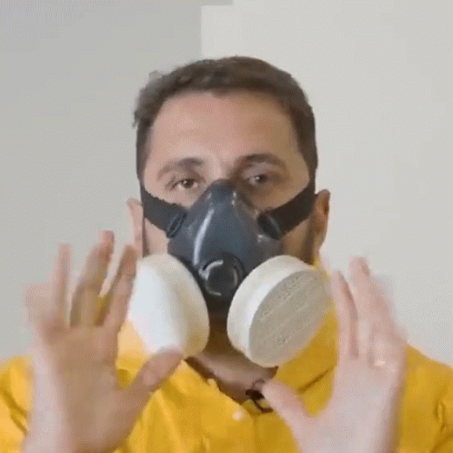 A Man Wearing A Gas Mask Holds His Hands Up GIF
