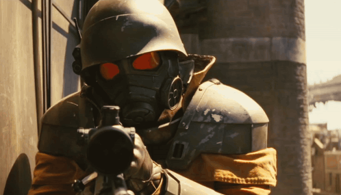 A Man Wearing A Gas Mask Is Holding A Rifle GIF