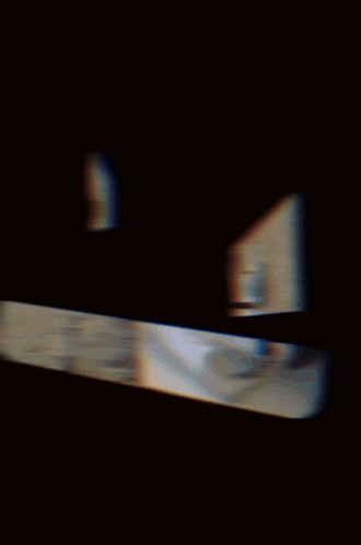 A Man Wearing A Gas Mask Is Sitting In Front Of A Brick Building GIF
