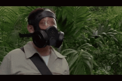 A Man Wearing A Gas Mask Is Standing In A Jungle With The Letters Ctv Hd On The Bottom Right GIF