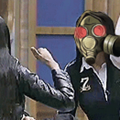 A Man Wearing A Gas Mask Is Standing Next To A Woman . GIF