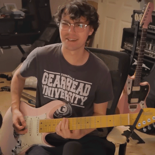 Man Playing Pink Guitar In Gearhead Shirt GIF