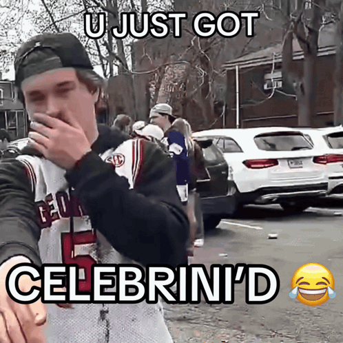 A Man Wearing A Georgia Jersey Is Covering His Mouth With His Hand GIF
