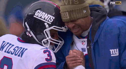A Man Wearing A Giants Hat Talks To A Player GIF