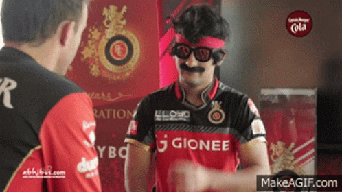 A Man Wearing A Gionee Shirt Is Talking To Another Man GIF