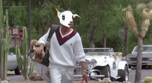 a man wearing a goat mask is walking down a street