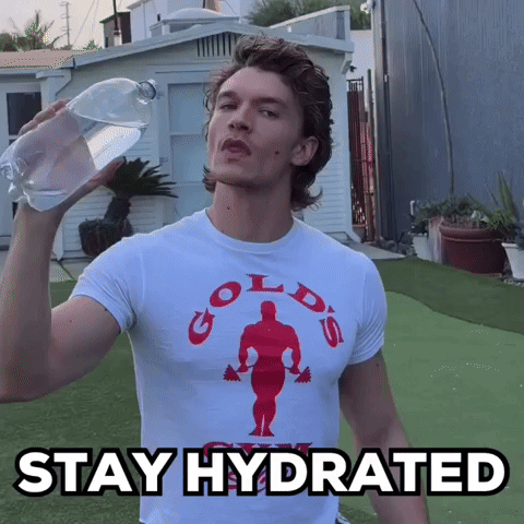 a man wearing a gold 's gym t-shirt is holding a bottle of water