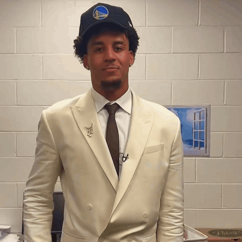 A Man Wearing A Golden State Warriors Hat And Suit GIF