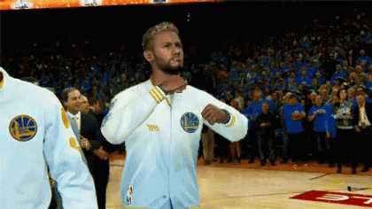 A Man Wearing A Golden State Warriors Jacket Stands On The Court GIF